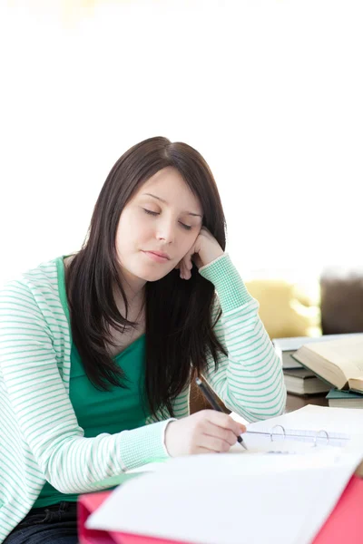 疲れ若い生徒が彼女の宿題をしながら眠っています。 — ストック写真