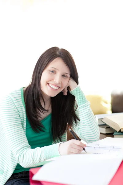 Sorrindo morena estudante fazendo sua lição de casa — Fotografia de Stock