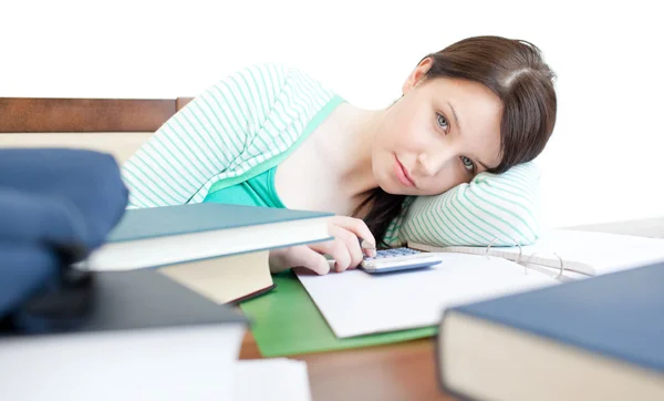 Mulher cansada atraente que estuda em uma mesa — Fotografia de Stock