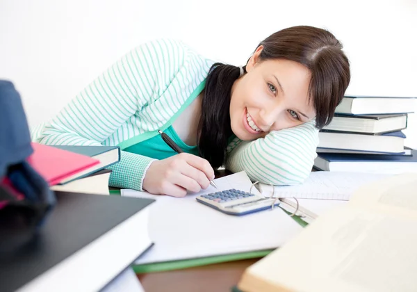 Leende student gör sina läxor på ett skrivbord — Stockfoto