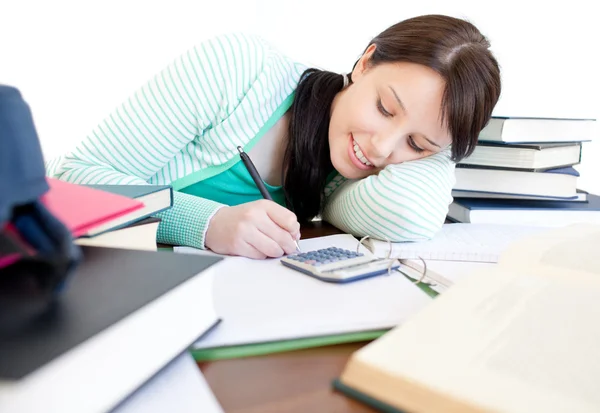 Attraktiva student gör sina läxor på ett skrivbord — Stockfoto