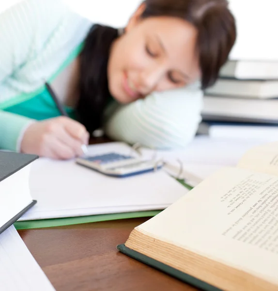 Studente bruna che fa i compiti su una scrivania — Foto Stock
