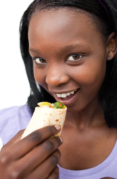 Χαμογελώντας νεαρή γυναίκα τρώει ένα περικάλυμμα — Φωτογραφία Αρχείου