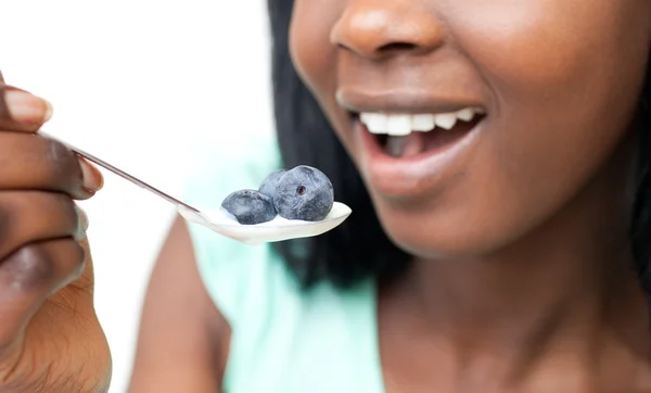 Närbild av en kvinna som äter en yoghurt med blåbär — Stockfoto