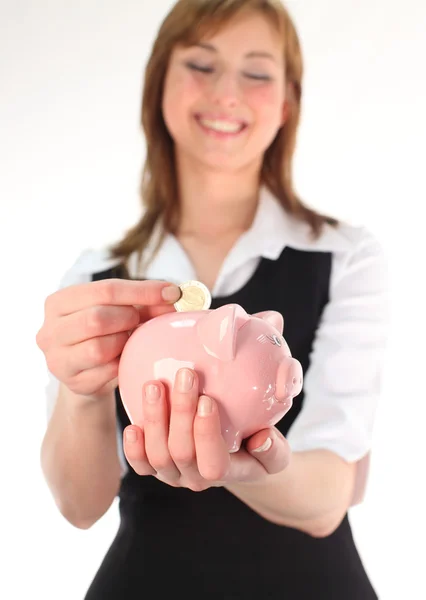 Kadın domuz kumbarasına para koyuyor. — Stok fotoğraf
