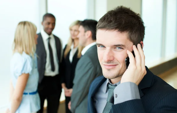 Hombre de negocios sonriente al teléfono en la oficina —  Fotos de Stock