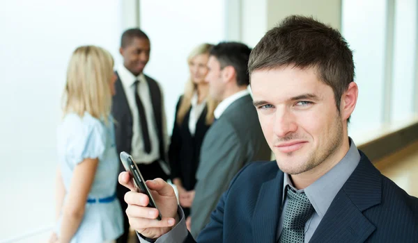 Happy businessman sending a text in office — Stock Photo, Image