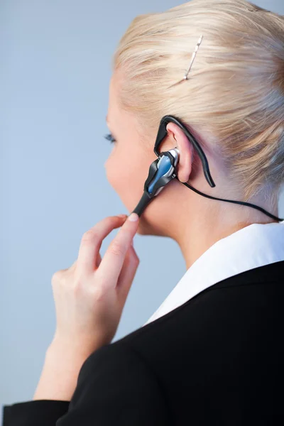 Mulher de negócios usando um fone de ouvido — Fotografia de Stock