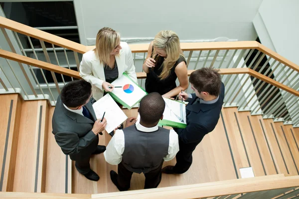 Vista alta da equipe de negócios que tem uma reunião nas escadas — Fotografia de Stock