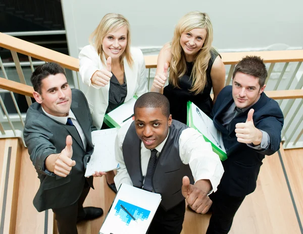 Business team having a meeting on stairs with thumbs up — Stock Photo, Image