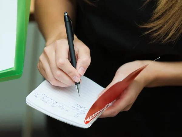 Blonde Geschäftsfrau schreibt auf ein Notizbuch — Stockfoto
