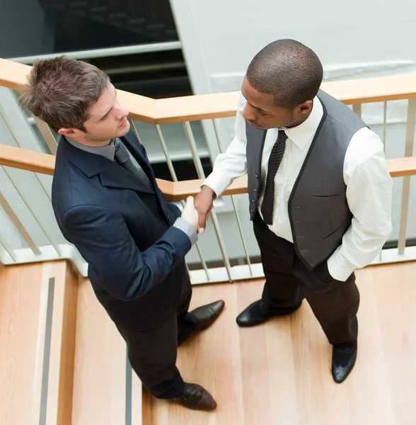 Два бізнесмени тремтять руками по сходах — стокове фото