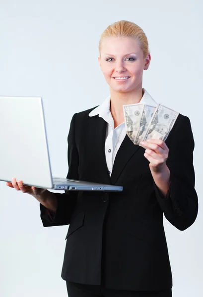 Mujer sosteniendo dólares y un portátil —  Fotos de Stock