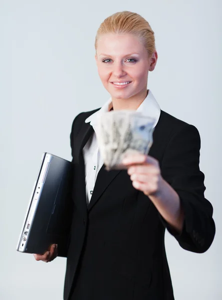 Mujer sosteniendo dólares y un portátil —  Fotos de Stock