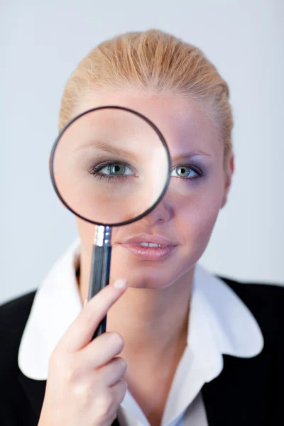 Grave donna d'affari guardando attraverso una lente d'ingrandimento — Foto Stock