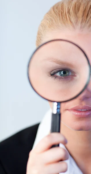 Serious Business woman looking through a magnifying Glass — Stock Photo, Image