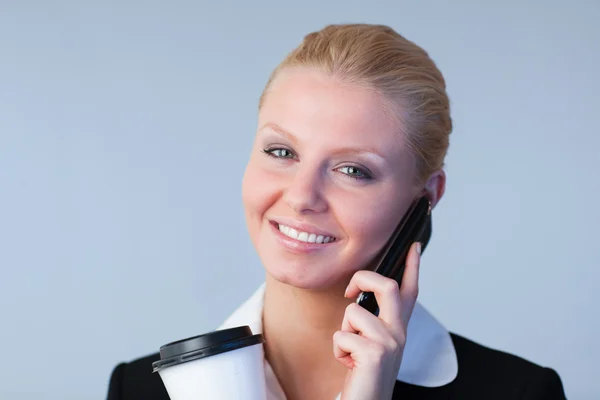 Kvinna prata i telefon som håller en kaffe behållare — Stockfoto