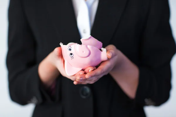 Zakenvrouw houden een gebroken piggy bank — Stockfoto