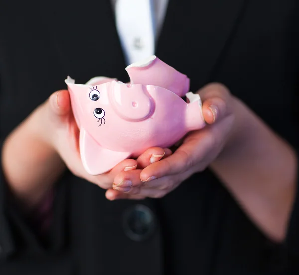 Business woman holding a broken piggy bank — Stock Photo, Image