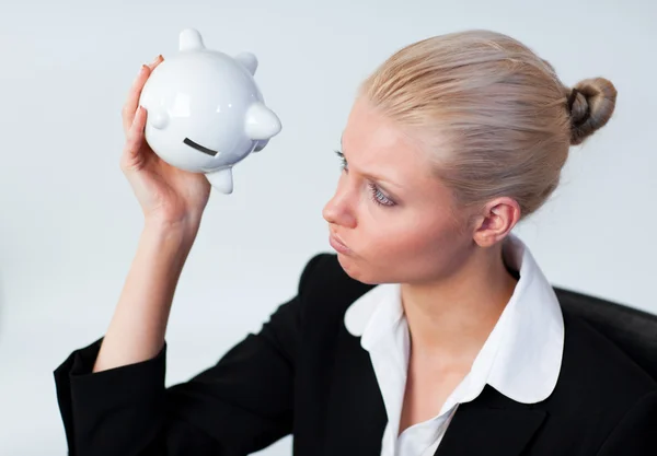 Smutny biznes kobieta patrząc w piggy bank — Zdjęcie stockowe