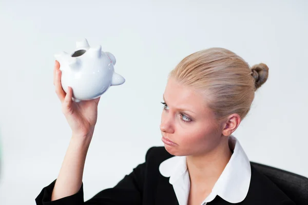 Triest zakenvrouw op zoek naar piggy bank — Stockfoto