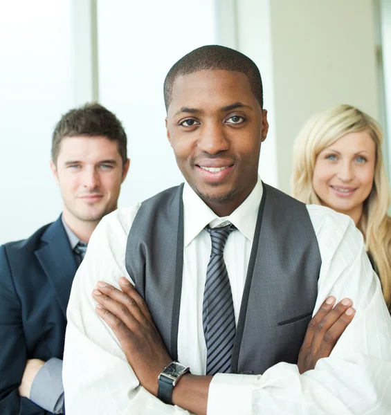 Hombre de negocios afroamericano con sus colegas sonriendo a la leva — Foto de Stock