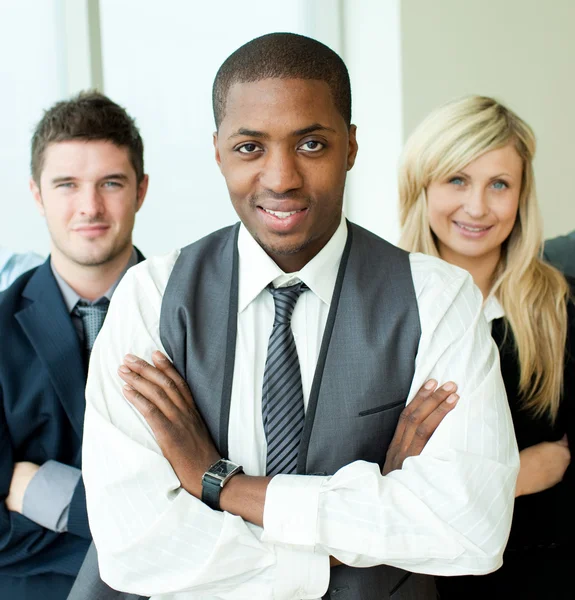 Афроамериканский бизнесмен со сложенными руками со своими коллегами — стоковое фото