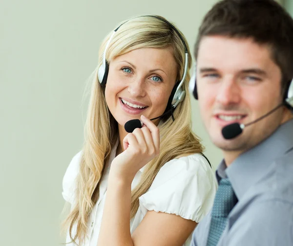 Twee business glimlachen op de camera met headsets — Stockfoto