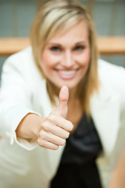 Geschäftsfrau lächelt mit erhobenem Daumen — Stockfoto