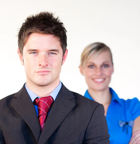 Serious businessman with businesswoman in the background — Stock Photo, Image