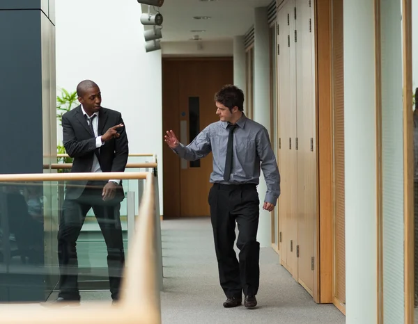 Uomini d'affari che salutano in un corridoio — Foto Stock