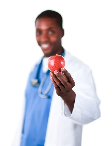 Médecin souriant tenant une pomme — Photo