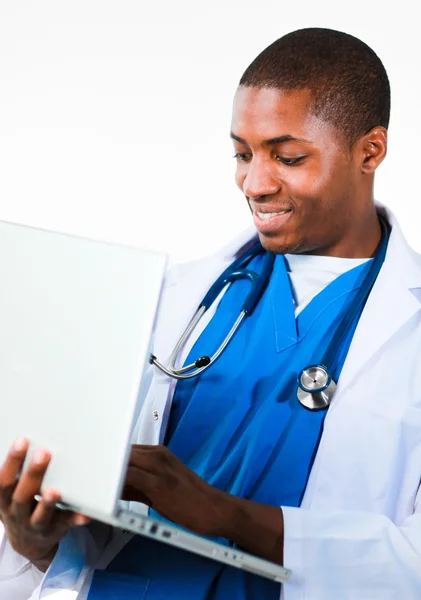 Médico afro-americano amigável trabalhando em um laptop — Fotografia de Stock
