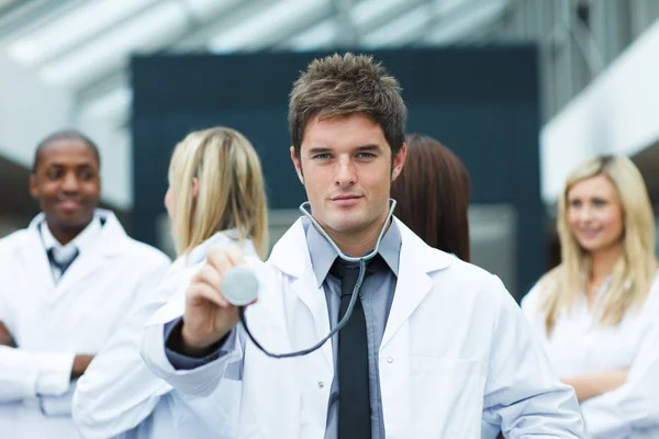 Knappe jonge dokter voor zijn team — Stockfoto