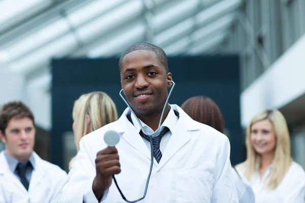 Ethnic doctor with his team in the background — Stock Photo, Image