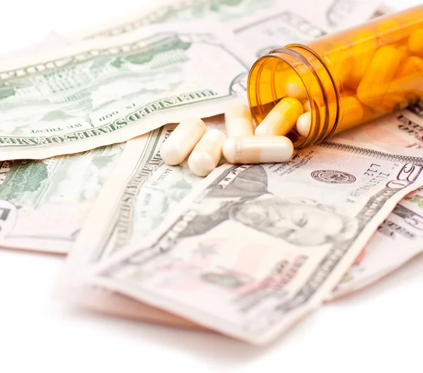 Pillen en dollars op witte achtergrond — Stockfoto