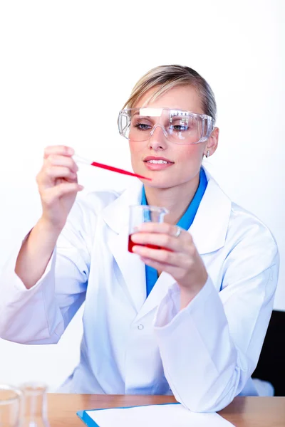 女性の科学者が試験管を調べる — ストック写真