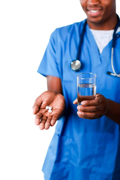 Young doctor showing pills and glass of water — Stock Photo, Image