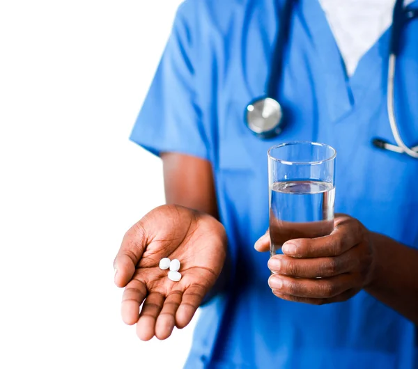 Крупним планом молодий лікар тримає таблетки і склянку води — стокове фото