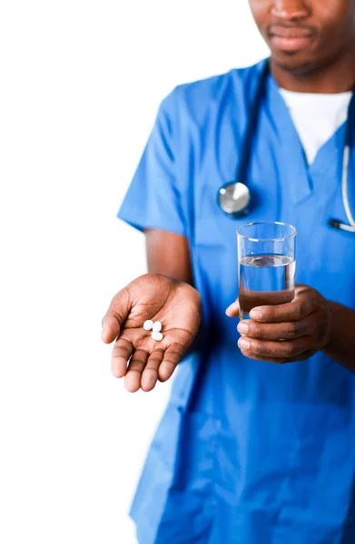 Confident doctor holding pills and glass of water — Stock Photo, Image