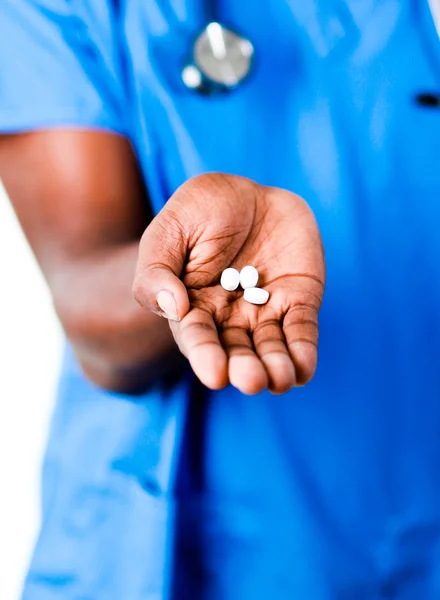 Close-up of an doctor holding pills and glass of water — Stock Photo, Image