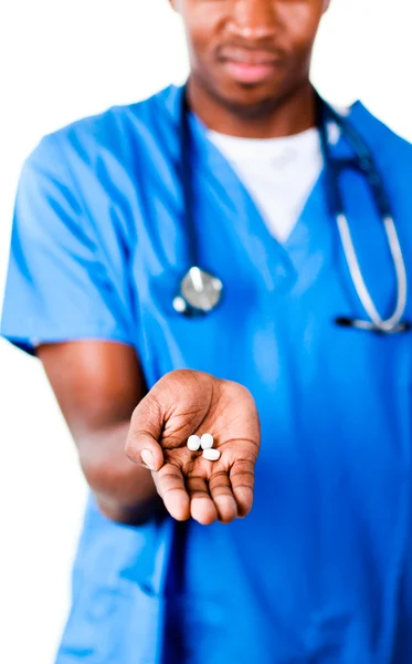 Serious doctor holding pills and glass of water — Stock Photo, Image