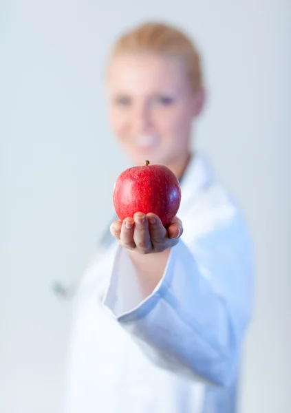 Доктор держит яблоко с акцентом на яблоко — стоковое фото