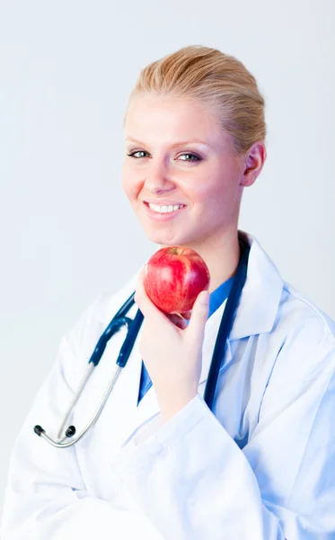 Doctor sosteniendo una manzana con enfoque en la persona —  Fotos de Stock