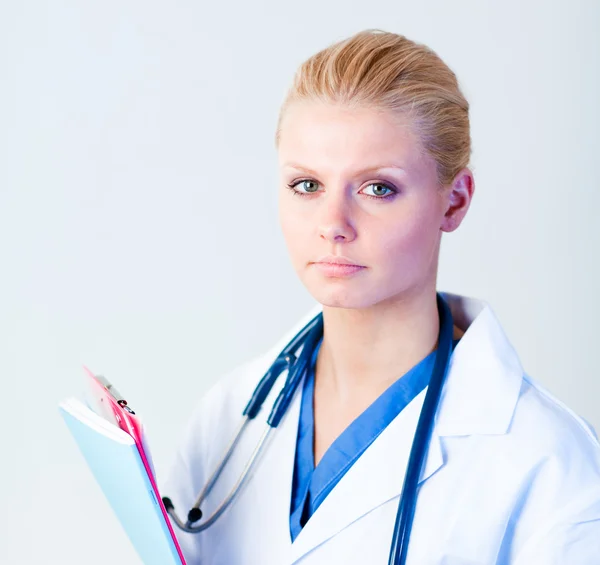 Serious doctor holding a clipboard — Stock Photo, Image