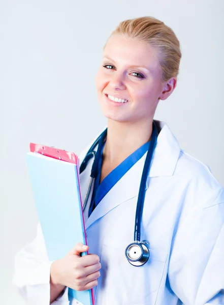 Femmina medico tenendo clip board e sorridente — Foto Stock