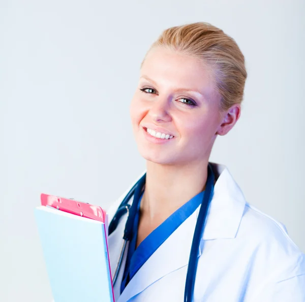Vrouwelijke arts holding clip boord en glimlachen — Stockfoto