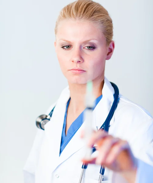 Médico sério segurando uma agulha — Fotografia de Stock