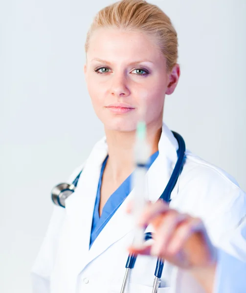 Médico sério segurando uma agulha com um toque de sorriso — Fotografia de Stock