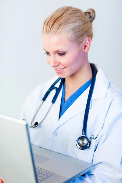 Bir dizüstü bilgisayarda çalışan genç bir kadın doktor — Stok fotoğraf